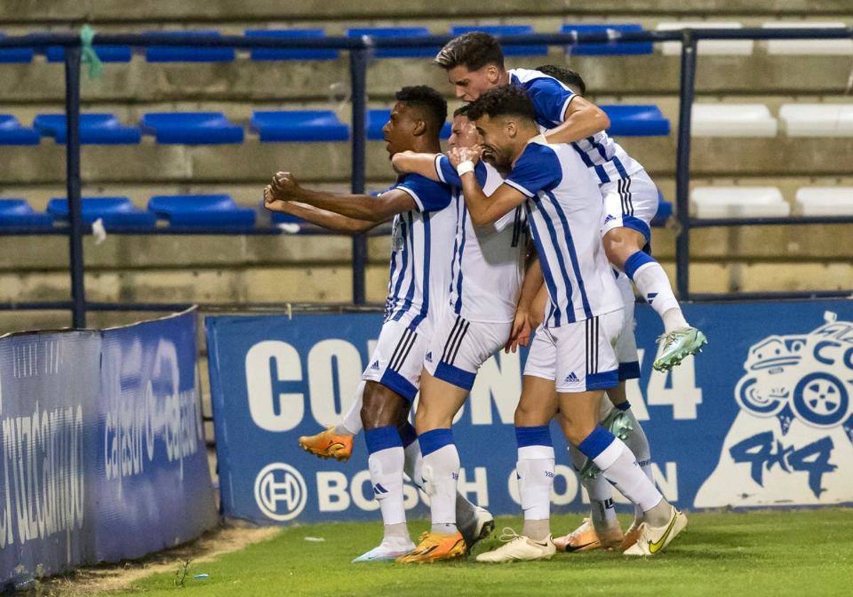 Los jugadores del Decano. como una piña, celebrando el 1-0