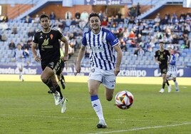 Juan Villar corre a por un balón con un jugador del Murcia detrás