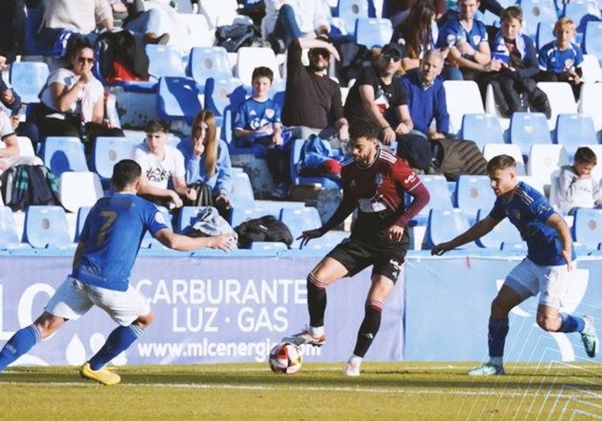 Luis Alcalde presionado por dos futbolistas del Linares