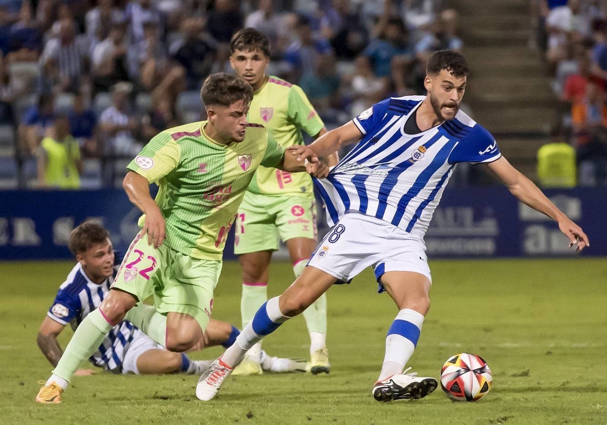 Luis Alcalde, agarrado por un rival en el Recreativo-Málaga