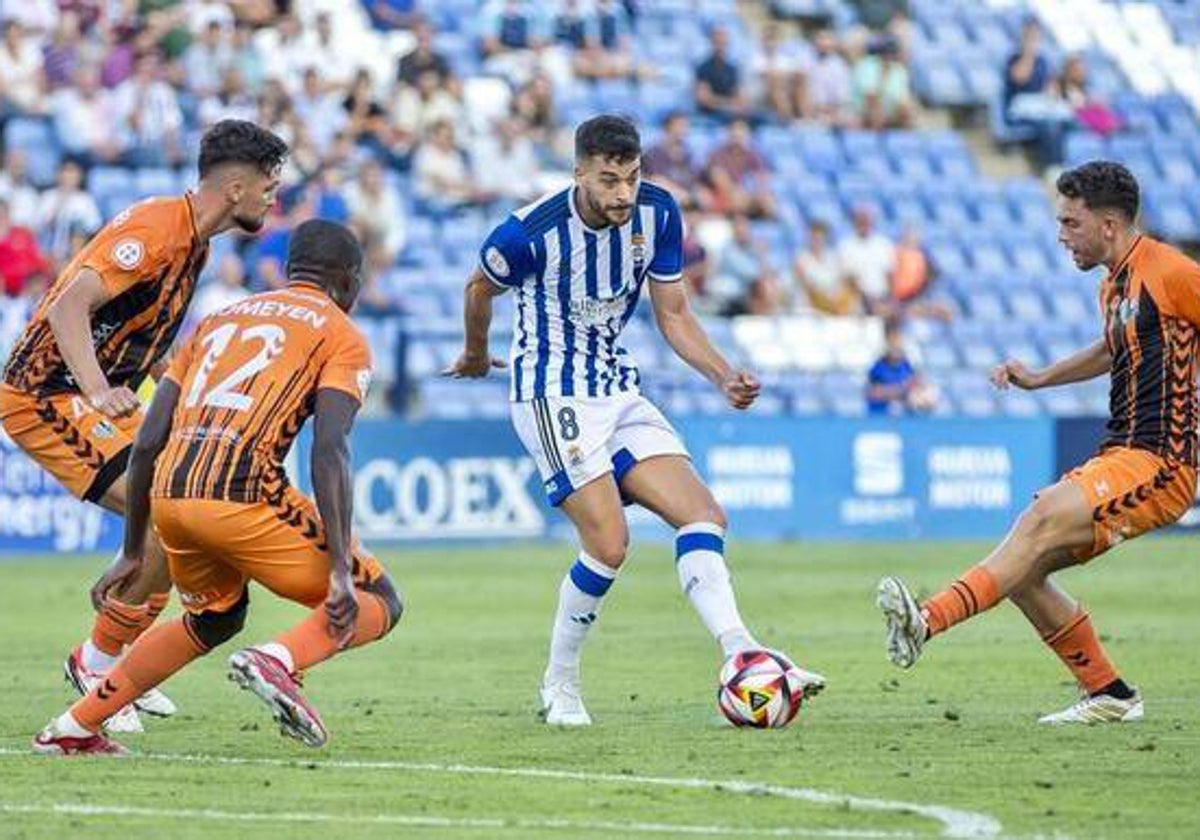 El futbolista del Recreativo Luis Alcalde, rodeado de jugadores del Antequera CF