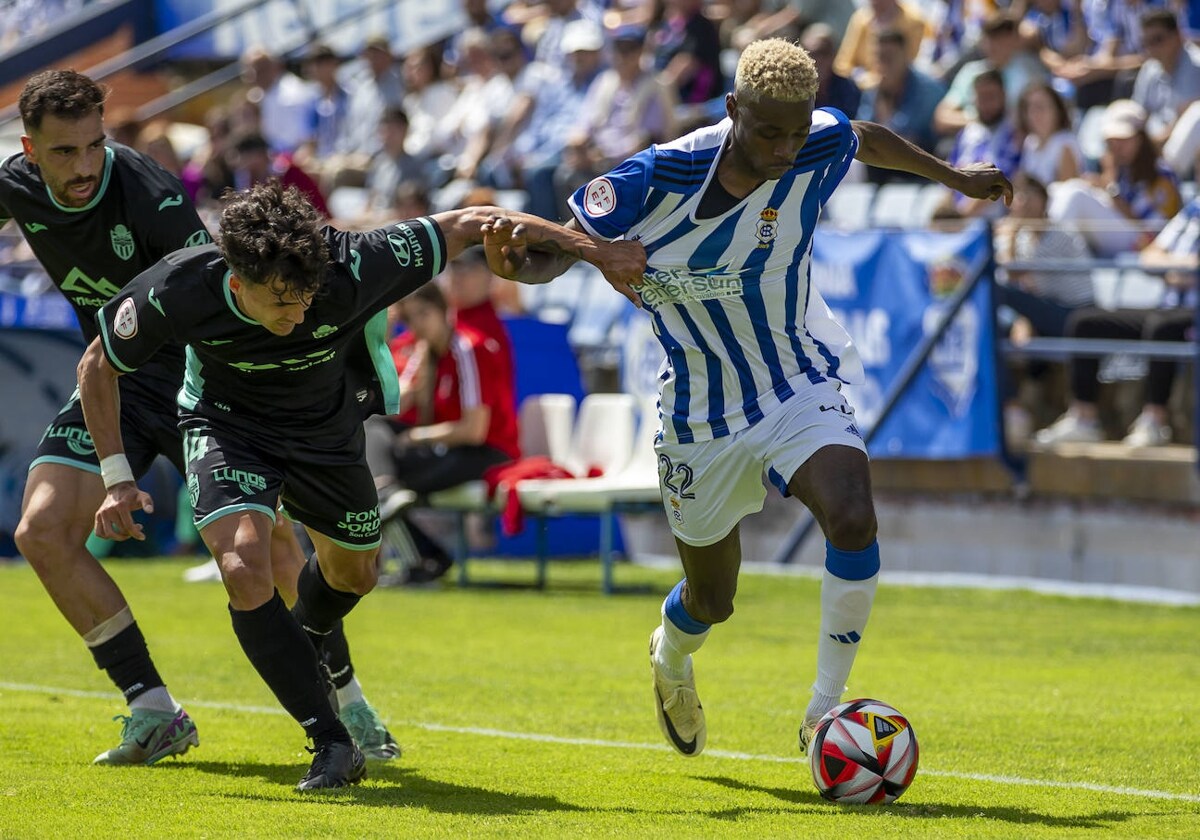 Rahim avanza con el balón agarrado por in rival en el Recreativo de Huelva- Atlético Baleares