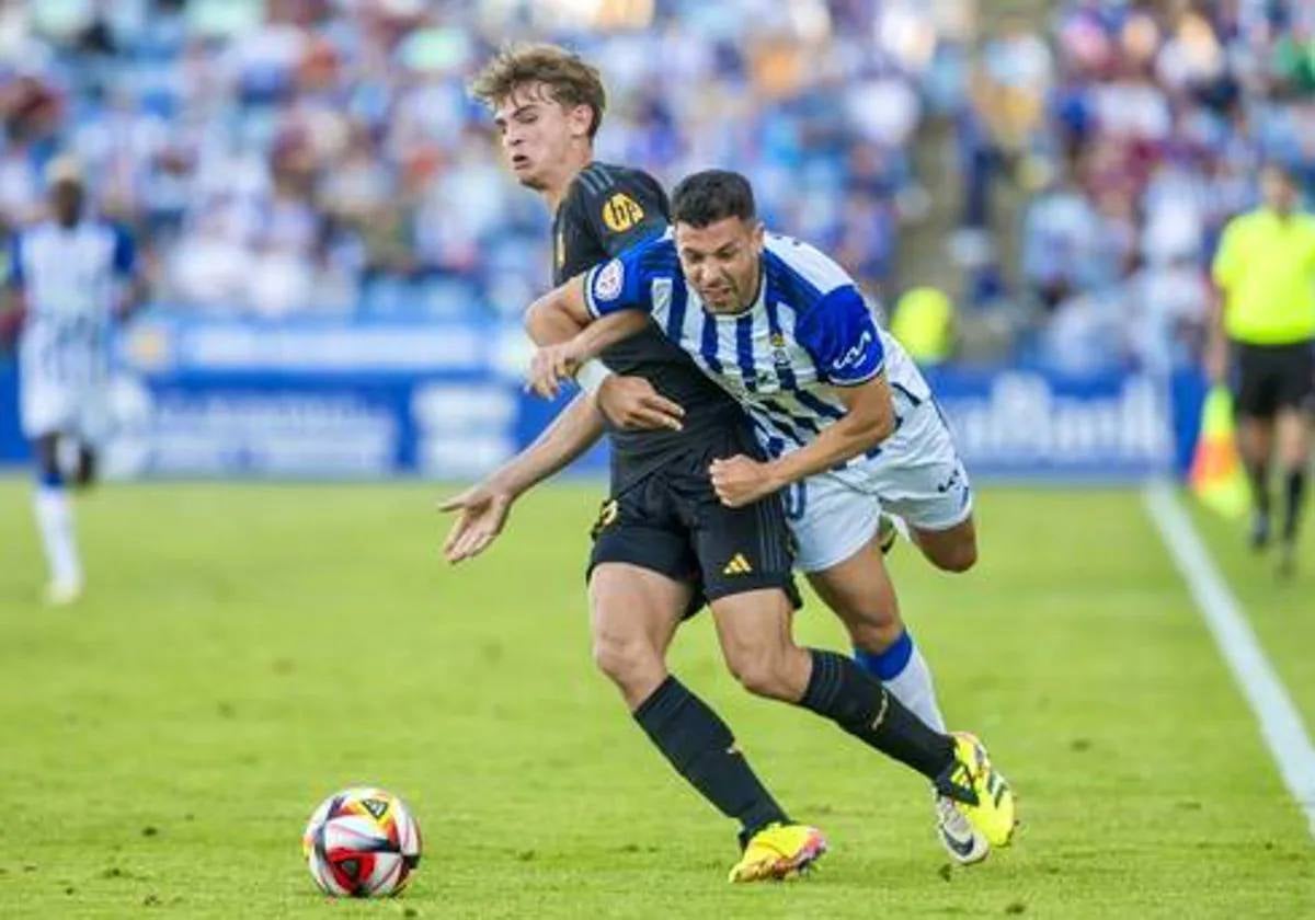 Álvaro Bustos entrado en falta por un rival durante el Recre-Real Madrid Castilla en el Colombino