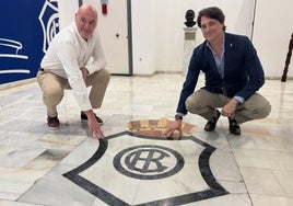 Roberto Ríos y Adrián Fernández, junto al escudo del Decano