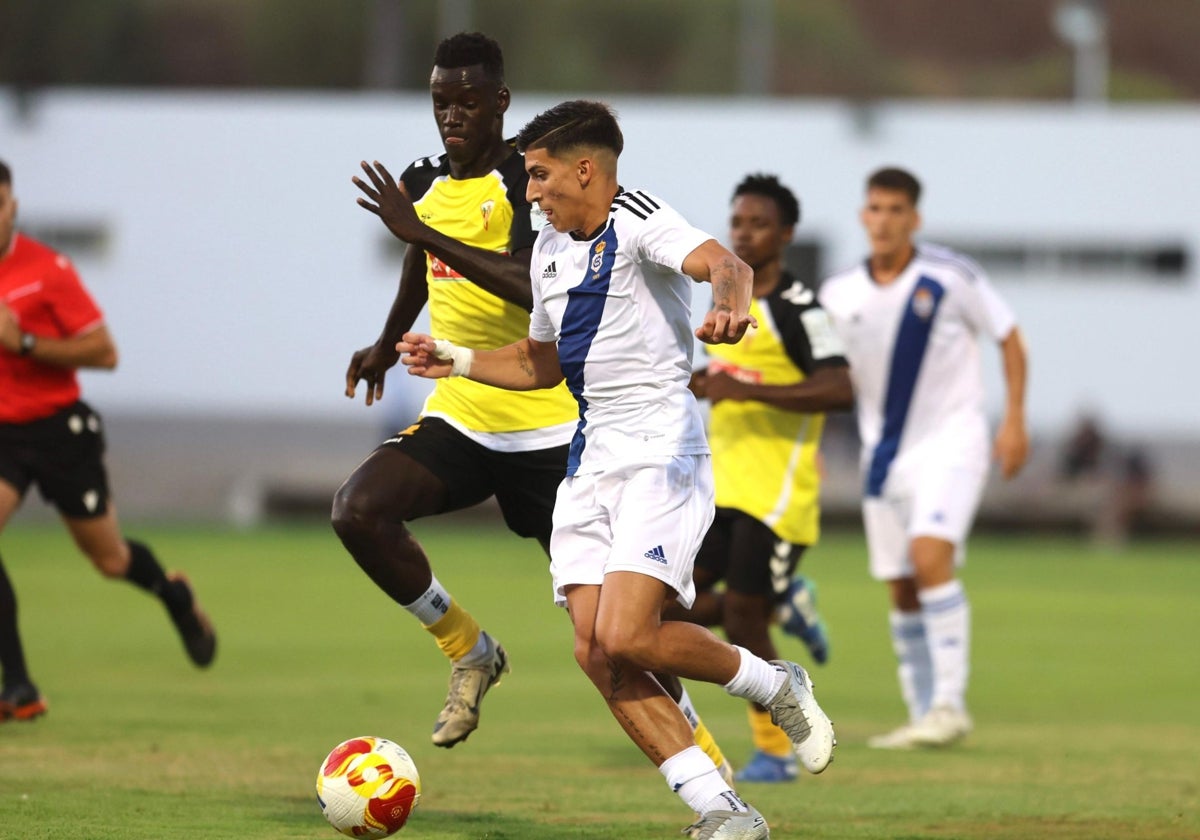 Paolo Romero conduce el balón atosigado por un rival del San Roque