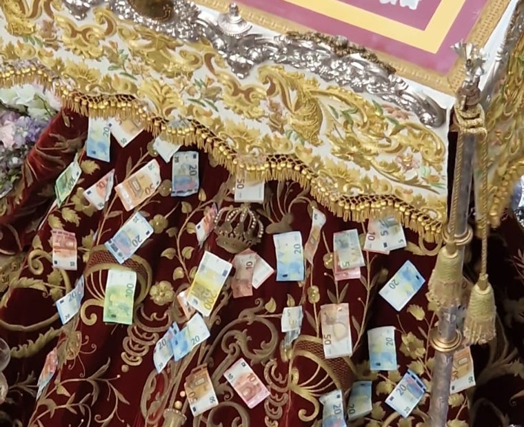 Billetes de diferente valor de curso legal, en el manto de la patrona de Lepe