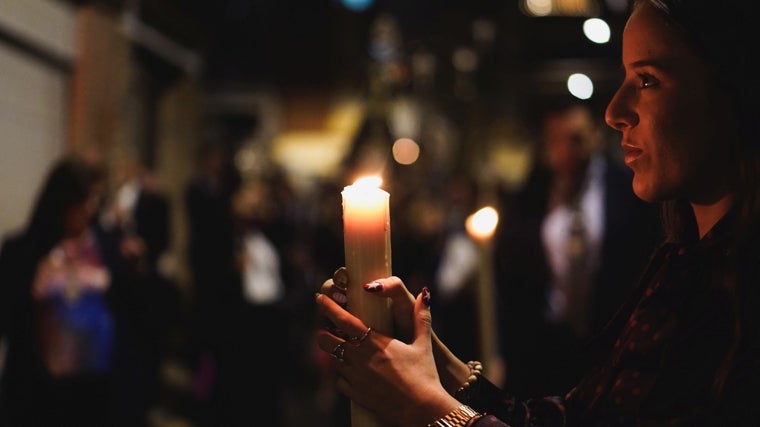 Hermanos iluminando el procesionar de la Virgen
