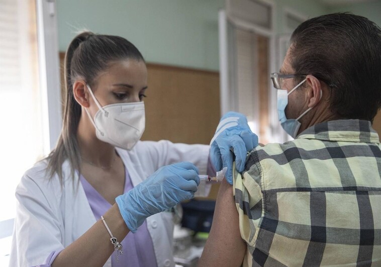 Una enfermera vacunando a un hombre contra la gripe