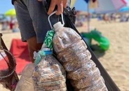 Un hombre recoge las colillas de la playa de Punta Umbría para realizar esculturas y concienciar a los bañistas
