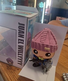 Imagen secundaria 2 - Juan en su bar Pancho demostrando su pasión por el fútbol y por la pesca, y abajo el funko que le han hecho en su honor