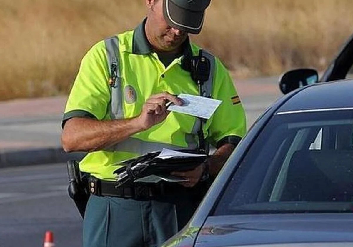 Imagen de archivo de un guardia de tráfico pidiendo la documentación a un conductor