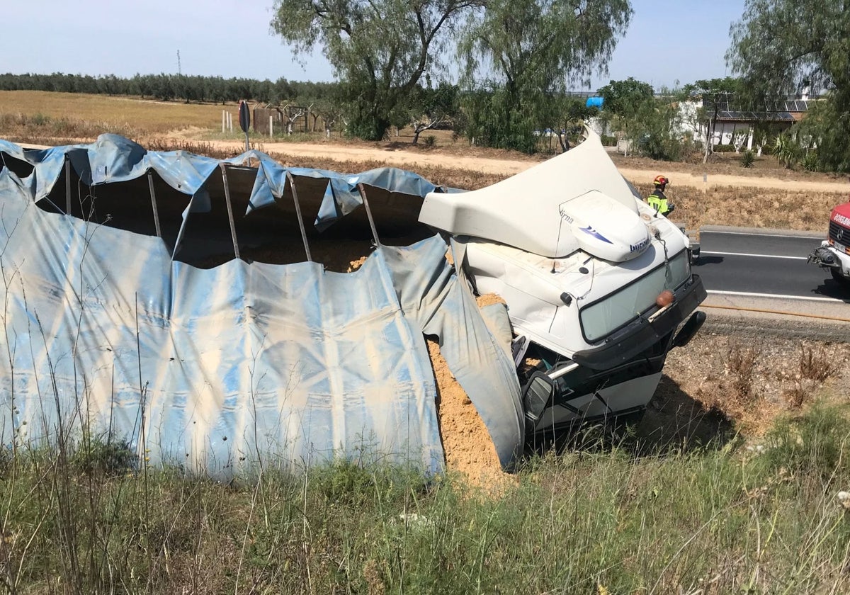 Camión cargado de arena volcado