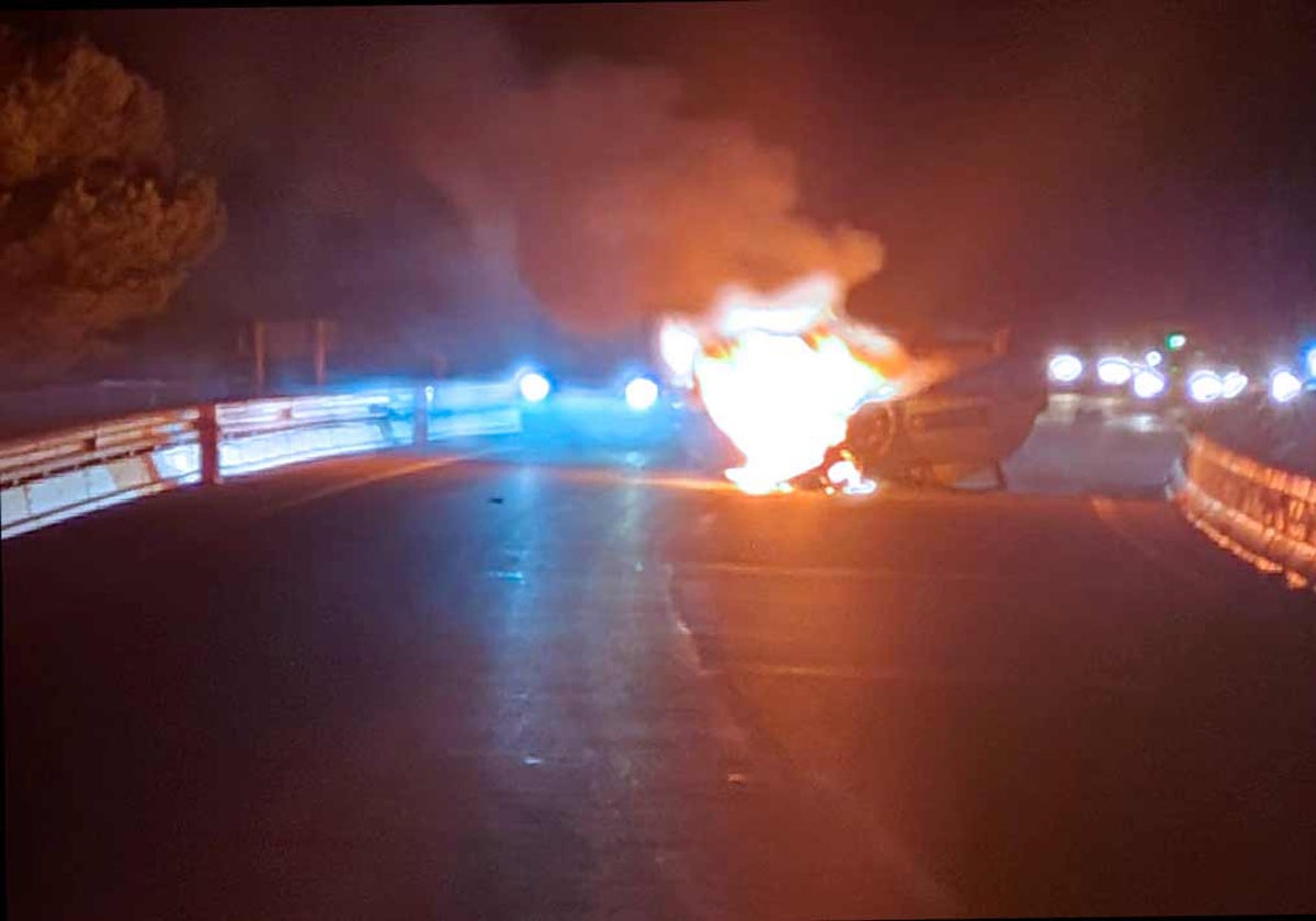 El coche aún en llamas sobre la calzada de la A-497