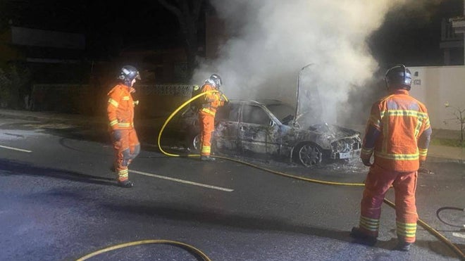 Los bomberos sofocando esta madrugada el incendio de un vehículo en Mazagón