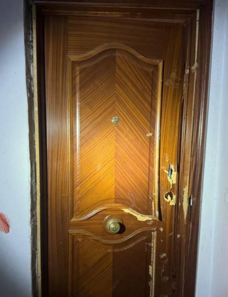 La puerta dañada debido a los golpes sufridos para intentar abrirla