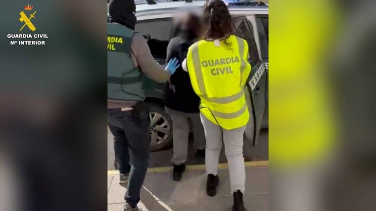 Uno de los detenidos en la operación entra en un vehículo de la Guardia Civil