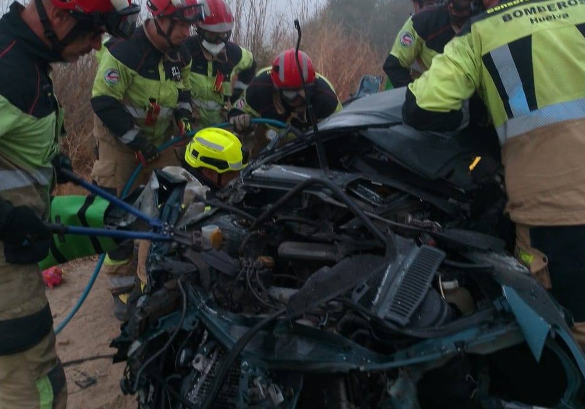 Bomberos en el lugar del accidente con el vehículo siniestrado