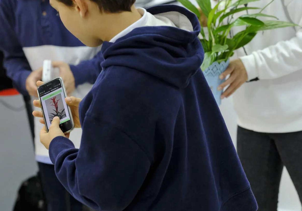 Un niño en el colegio con su teléfono móvil