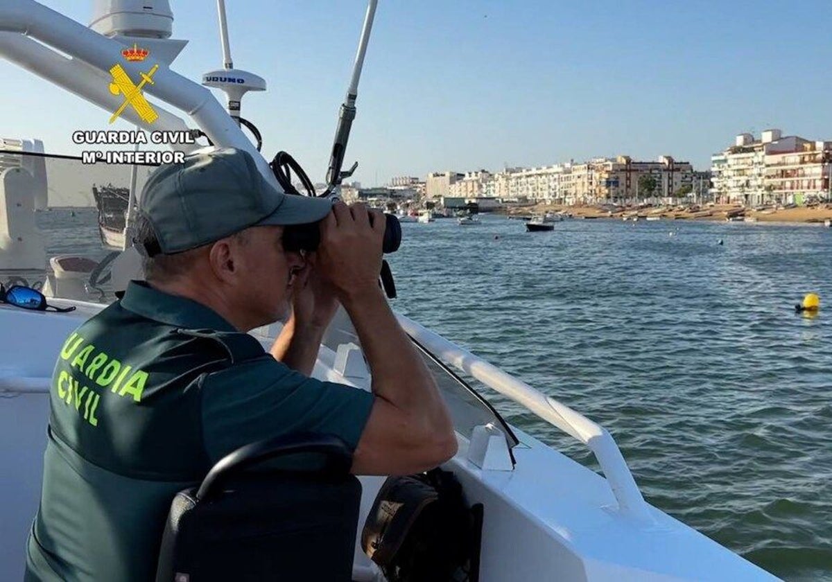 Un agente haciendo labores de vigilancia desde una embarcación en una de las playas de la costa de Huelva