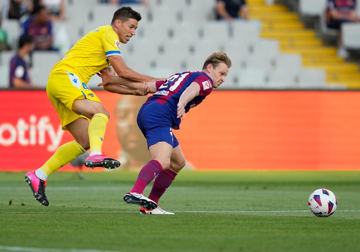 Rubén Alcaraz, centrocampista del Cádiz CF, trata de frenar al culé Frenkie De Jong.