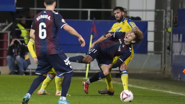 Jorge Pascual recibe la falta de Glauder en presencia de Sergio Álvarez durante el Eibar - Cádiz en Ipurúa.
