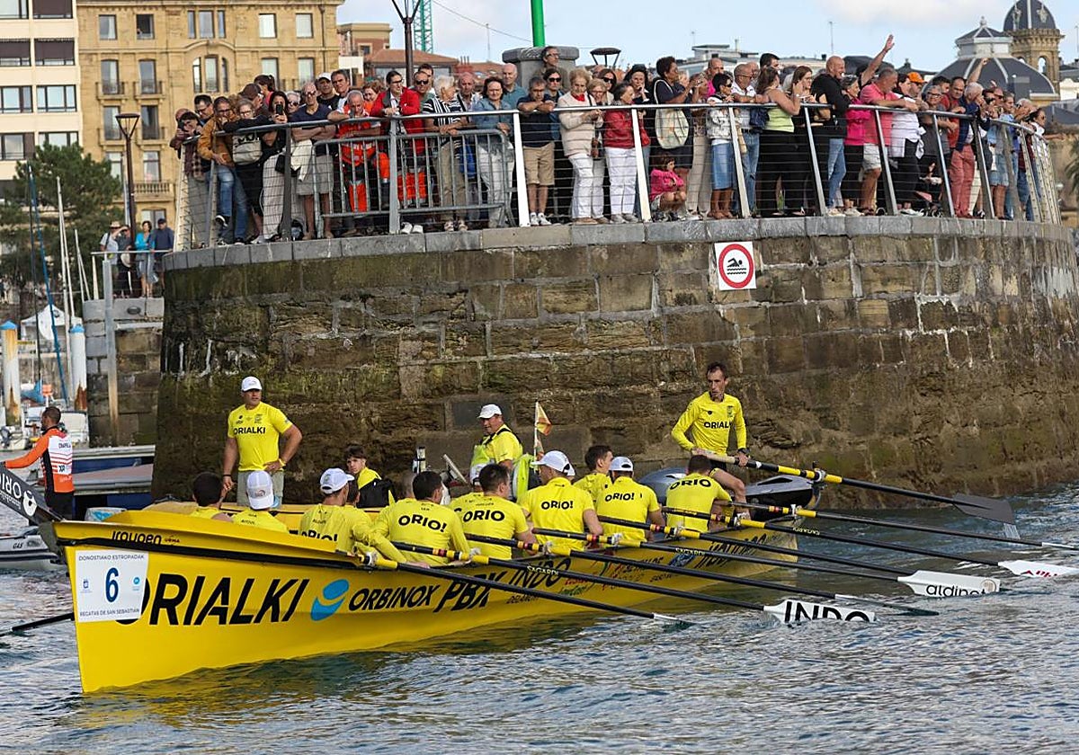 Decenas de donostiarras observan la trainera favorita en el muelle donostiarra.