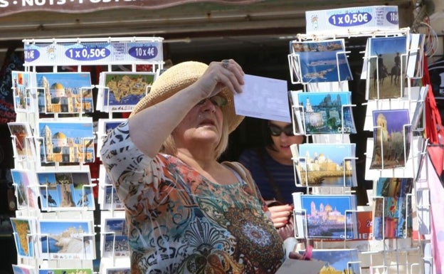 Turista comprando postales