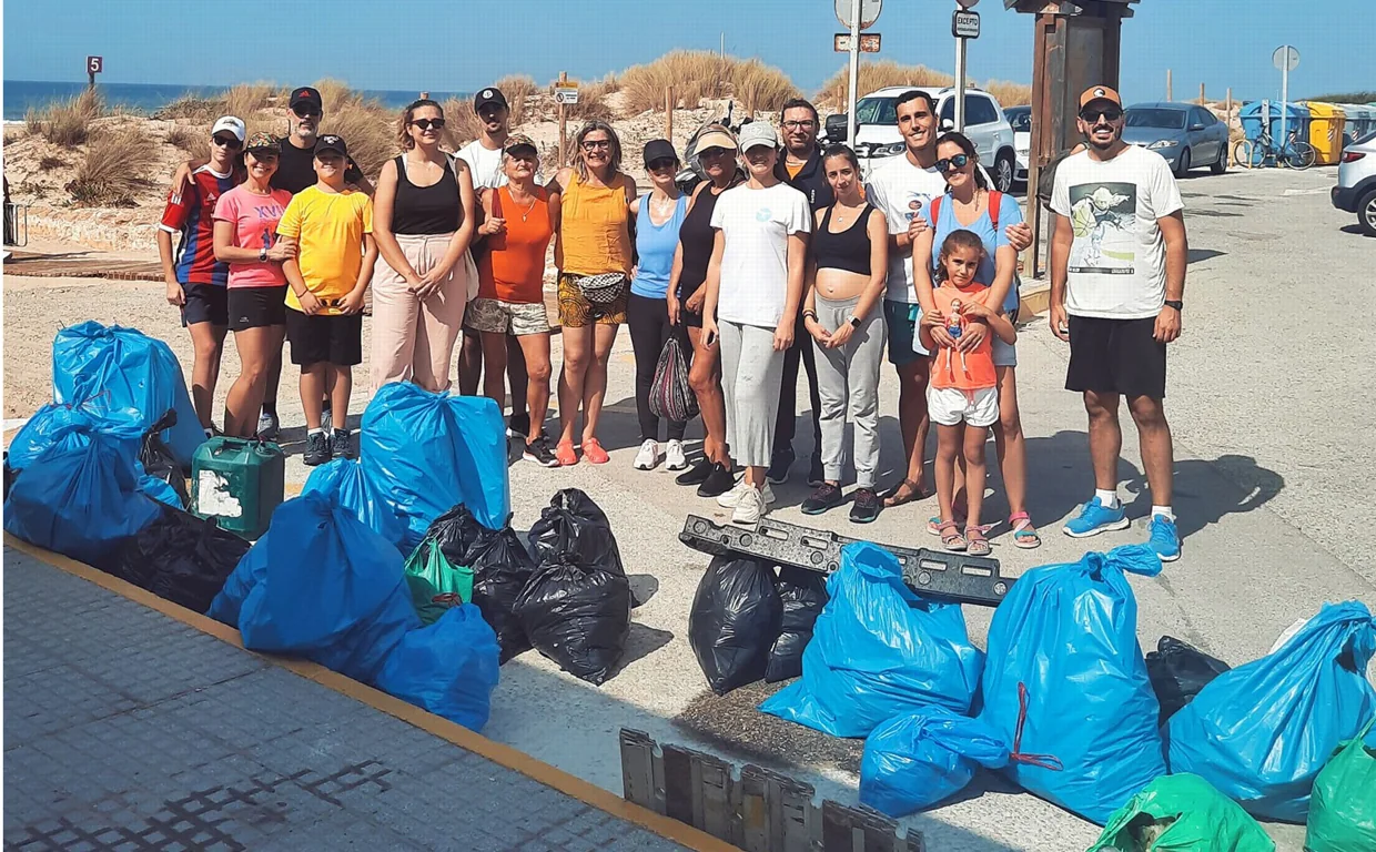 Los voluntarios con las bolsas repletas de basura que recogieron en la playa.
