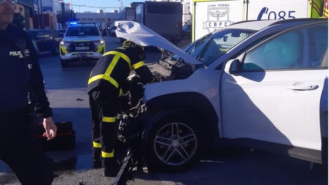 Bombero trabaja en uno de los vehículos implicados en el accidente