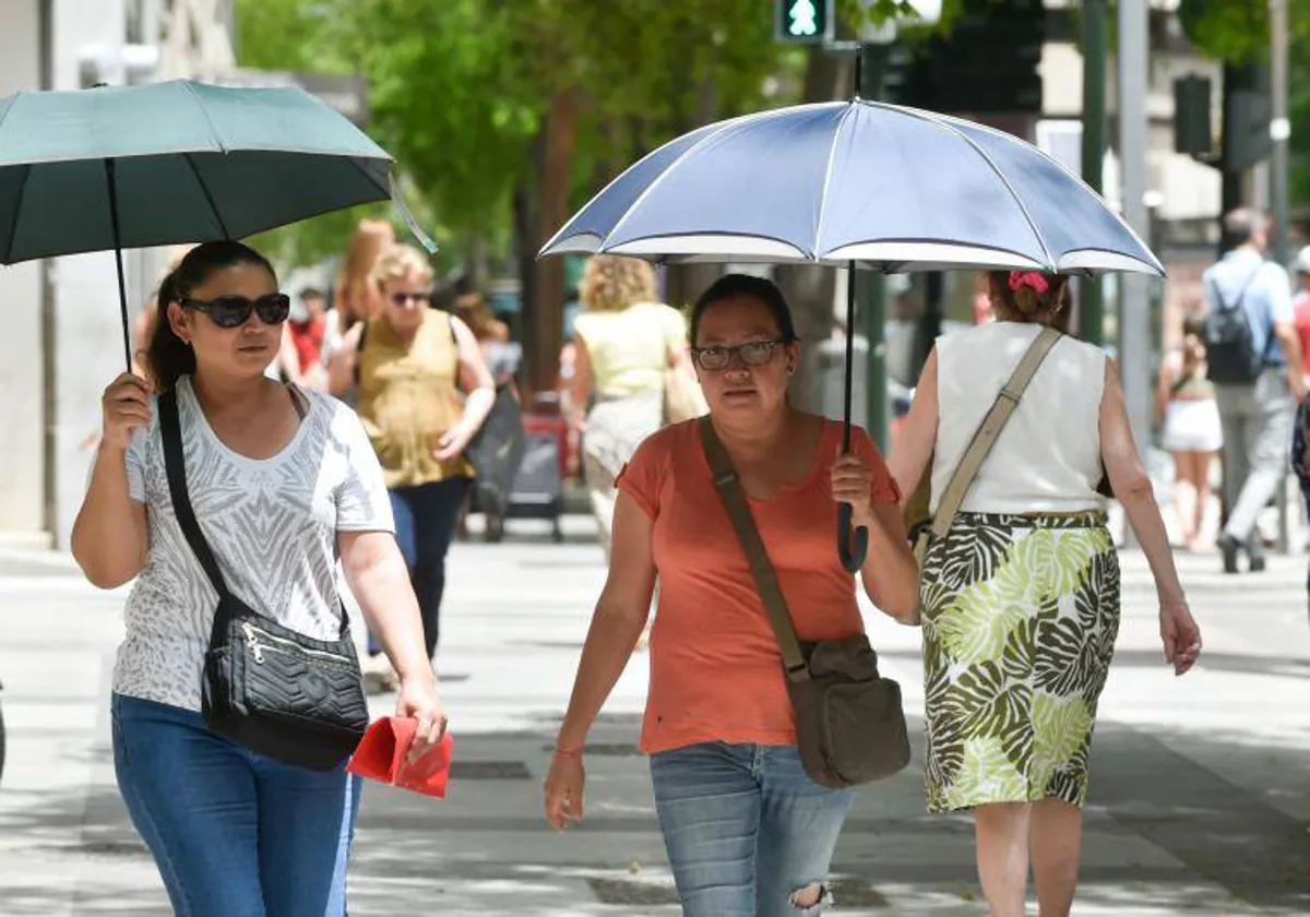 Dos mujeres se protegen del sol con un paraguas