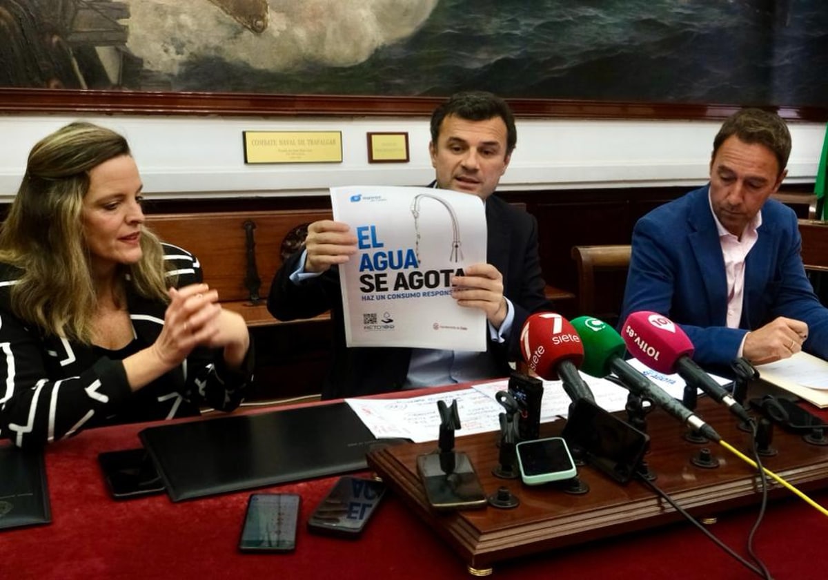 El alcalde muestra el cartel de la campaña de sensibilización que va a poner en marcha Aguas de Cádiz.