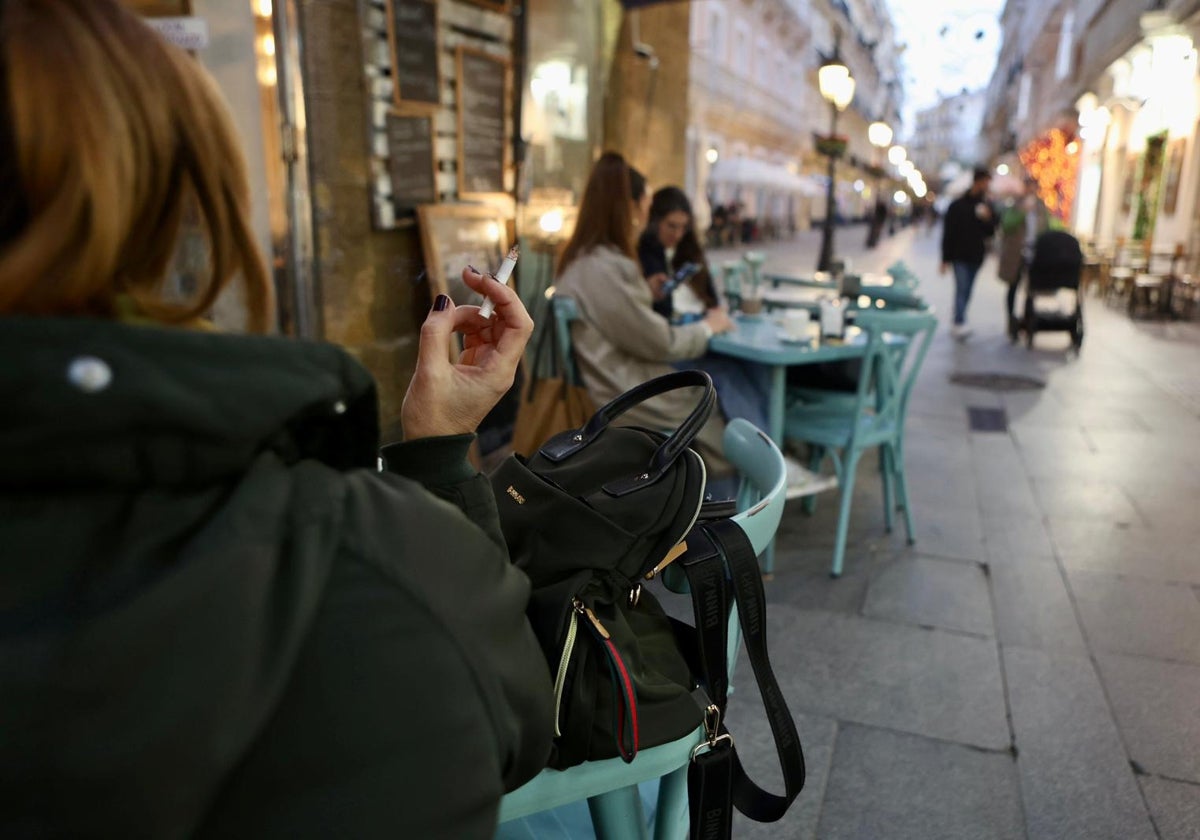 Una mujer fuma en una terraza de Cádiz