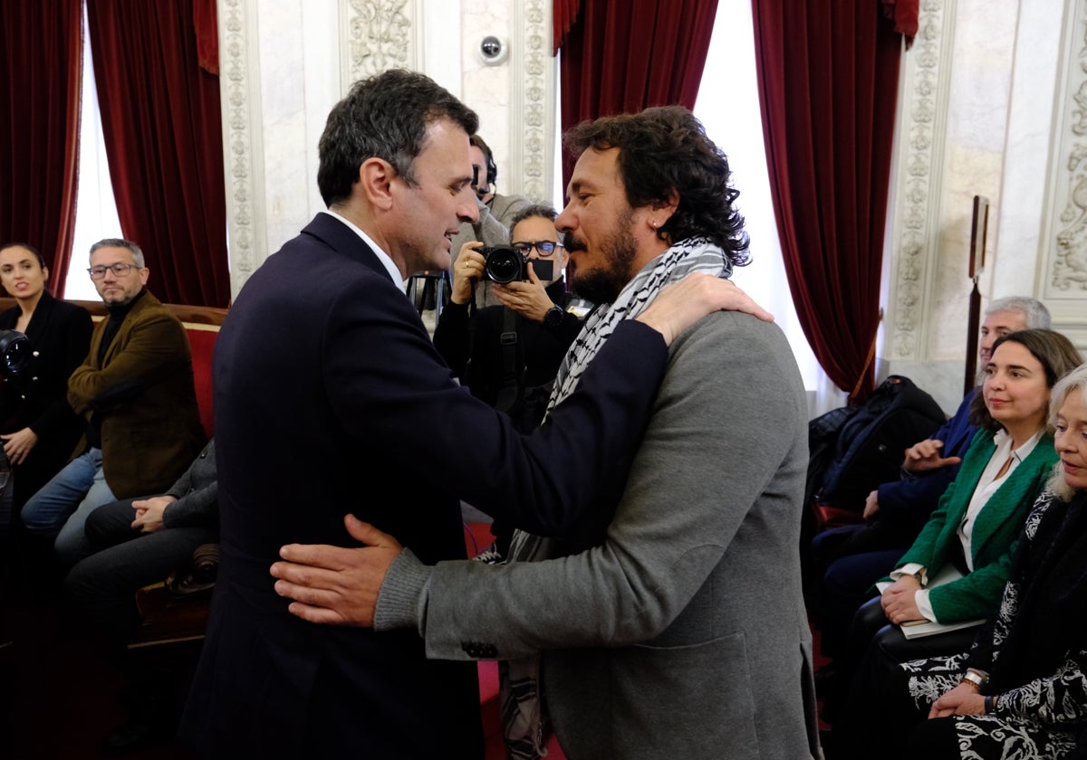 Bruno García y José María González se saludan con un abrazo al inicio del pleno extraordinario en memoria de Carlos Díaz.