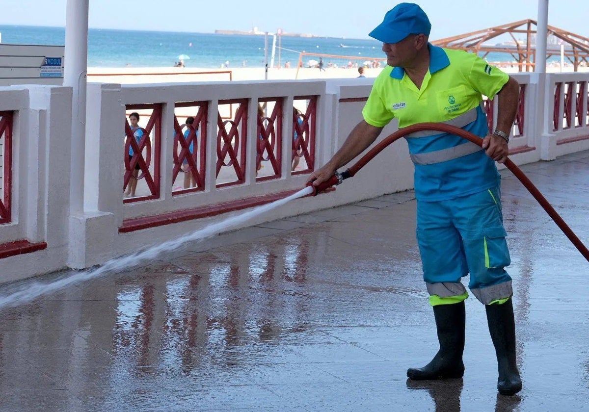 Un operario del servicio baldeando el Paseo Marítimo, en una imagen de archivo.