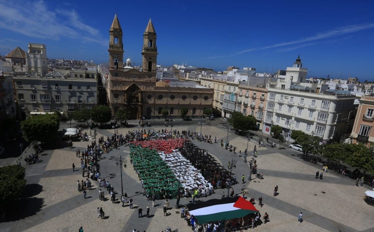 Imagen principal - Una bandera gigante visibiliza en Cádiz el genocidio de Israel en Palestina