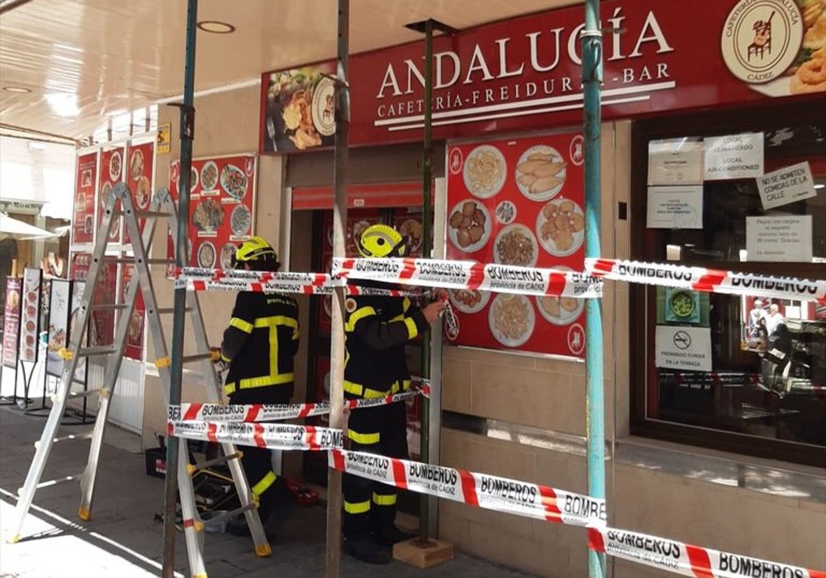 Operarios de bomberos inspeccionando la parte externa del local