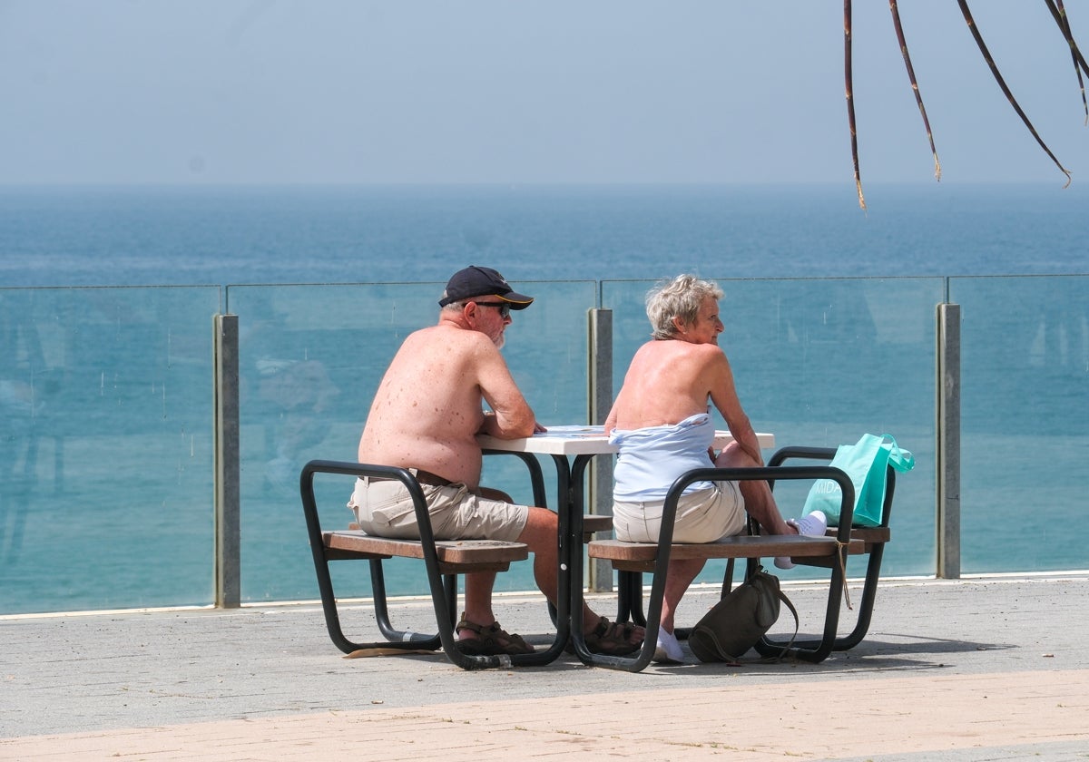 Una pareja, en una de las mesas instaladas arriba de la playa de Santa María del Mar de Cádiz