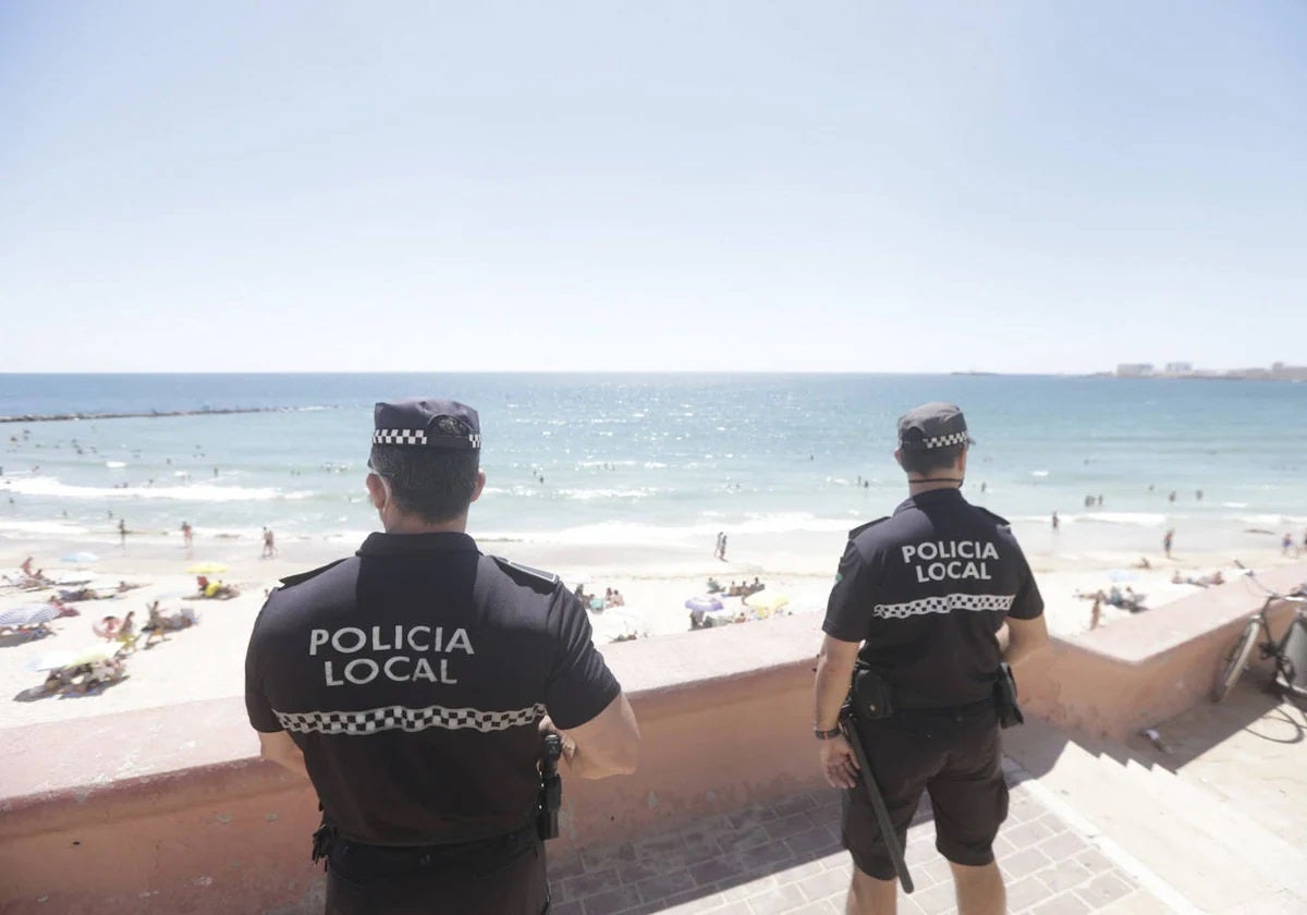 Dos agentes de la Policía Local de Cádiz vigilando la playa de Santa María del Mar