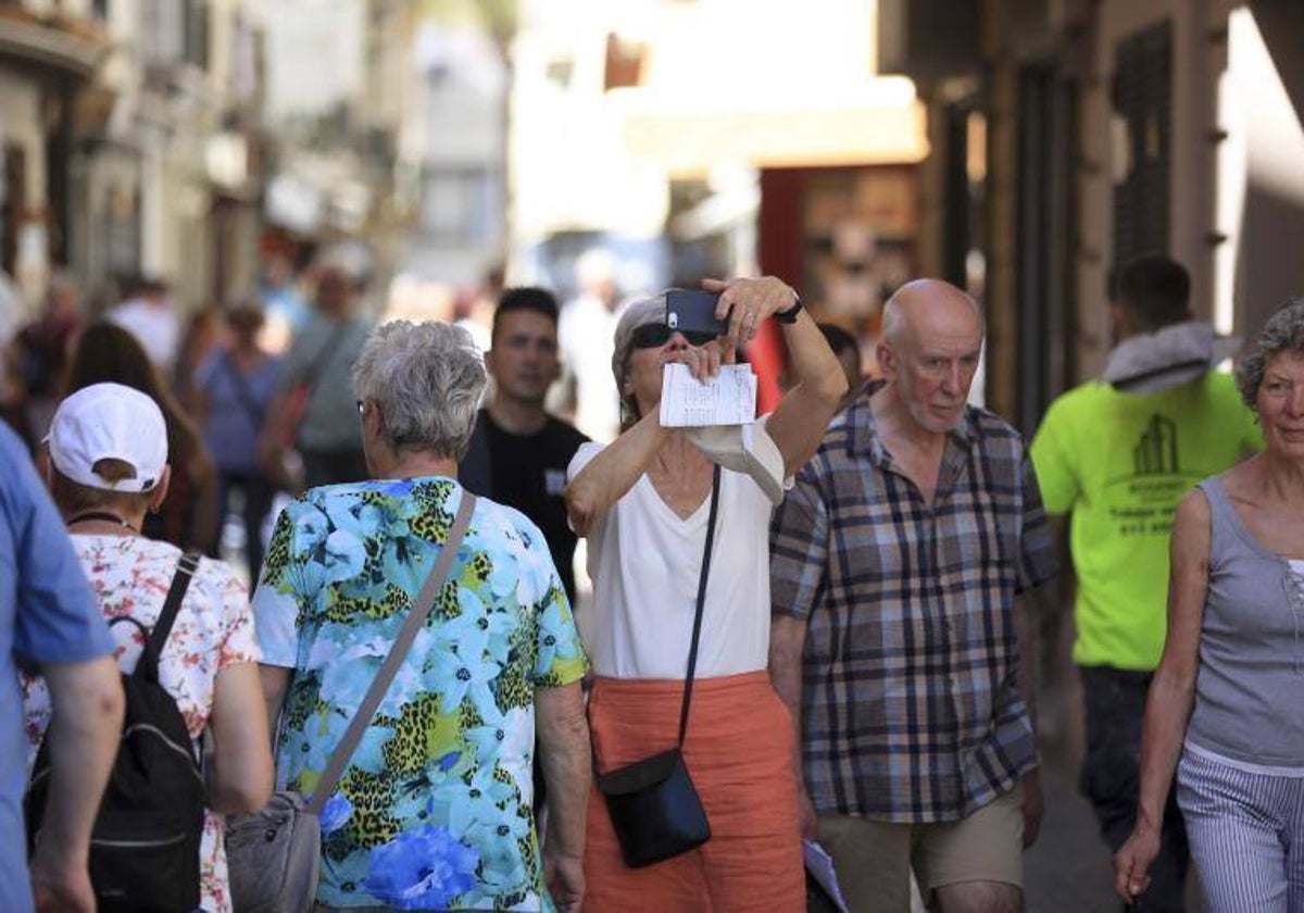 Una turista saca una foto con su móvil en el centro de Cádiz.