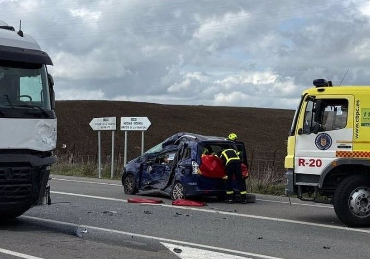 Bomberos trabajando en el coche siniestrado en la A-396 a la altura del cruce de Benalup