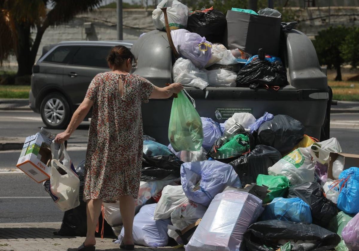 Una mujer tira la basura en Sanlúcar