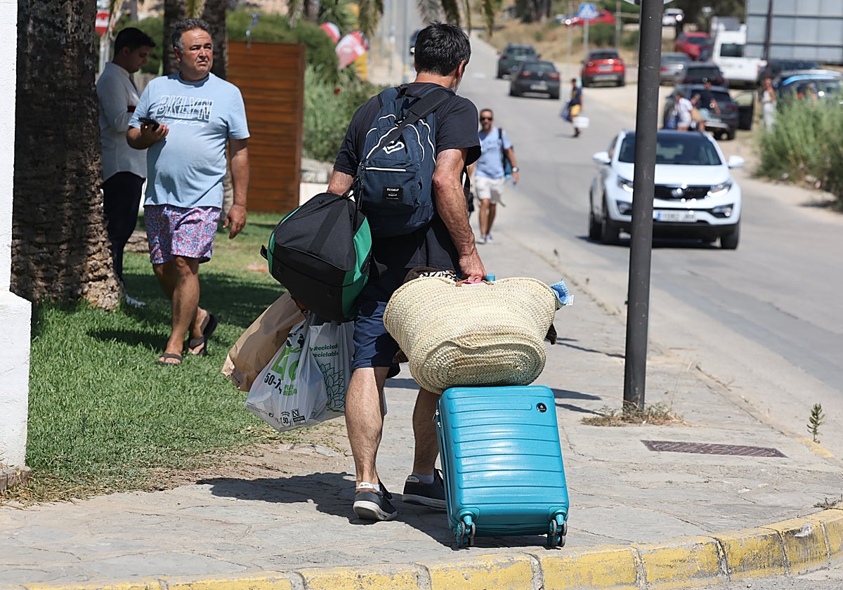 Un turista con las maletas, este pasado martes tras el incendio, en Zahara.