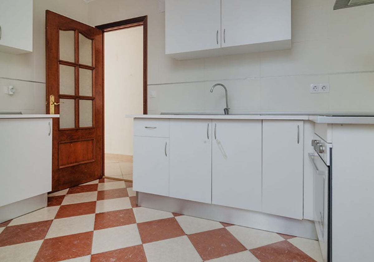 La vivienda cuenta con una cocina amplia, equipada con muebles blancos en buen estado.