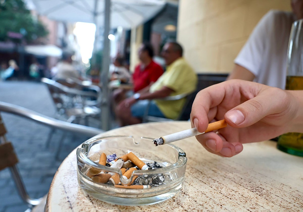 Una mujer fuma en la terraza de un bar de Cádiz