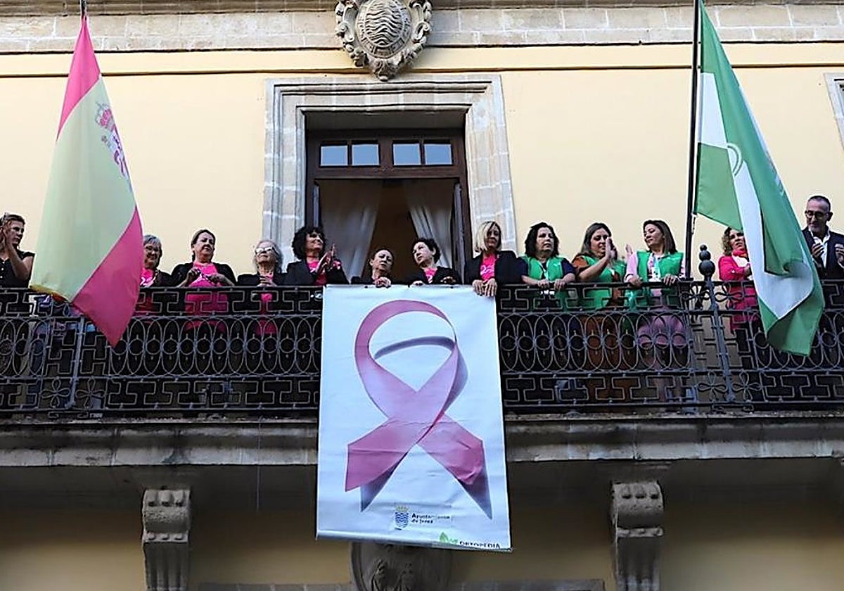 Colocación del lazo rosa por el cáncer de mama en el balcón del Ayuntamiento de Jerez