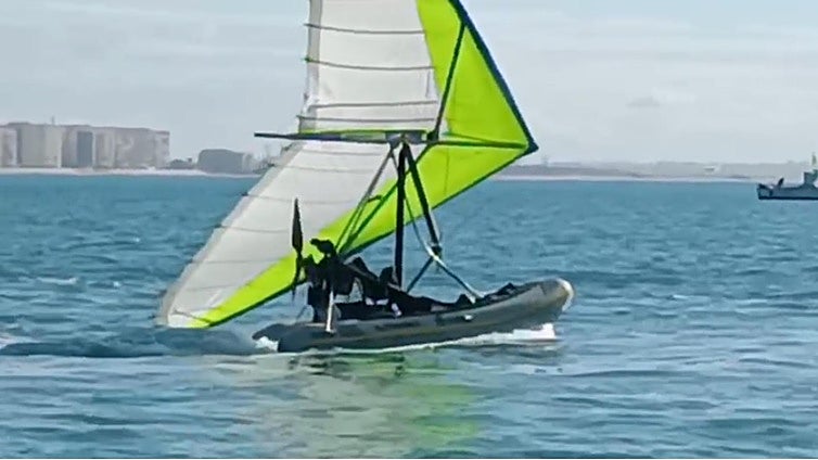 Cae al agua cuando intentaba cruzar la Bahía de Cádiz con una zódiac voladora: una hinchable con un motor y un ala-delta