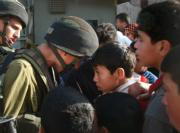 Un niño palestino se enfrenta a un soldado israelí en un «checkpoint» que deben cruzar para ir a la escuela en Hebrón