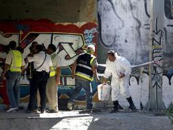 Los artificieros del Cuerpo Nacional de Policía, en el momento de desactivar el tercer explosivo colocado por ETA en la costa de Málaga, situado bajo un puente de la A-7. /EFE