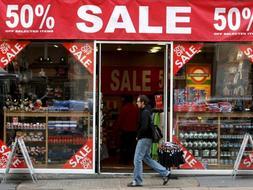 Un hombre pasa por delante de una tienda que ofrece grandes descuentos en una céntrica calle de Londres./ Efe