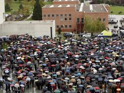 Pese a la lluvia, cientos de personas se han concentrado en la explanada de la Universidad de Navarra como símbolo de condena al atentado. /EFE